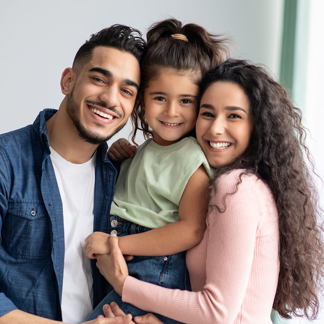 A happy family posing together with smiles on their faces.